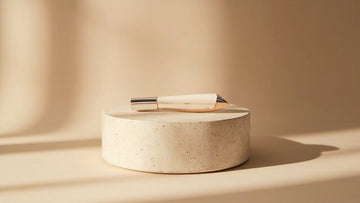minimalist product still life on stone pedestal in soft warm studio light